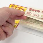 Photo of someone grabbing a coupon out of a hard card pop'nsell that can add value to a brand